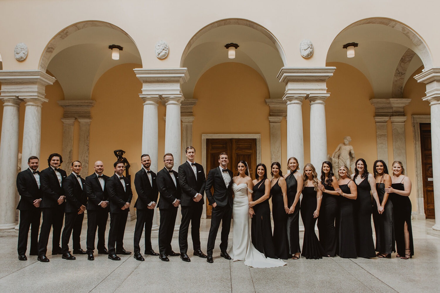 couple pose with wedding party in the Walters Art Museum