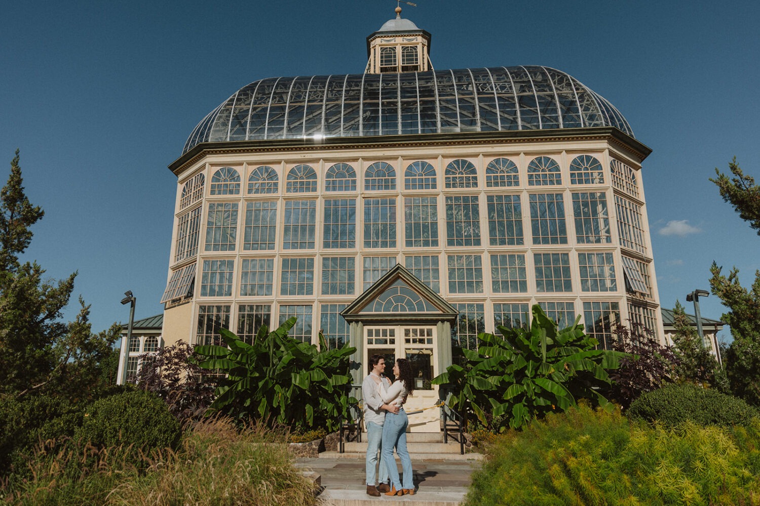 couple poses in front of the Rawlings Conservatory