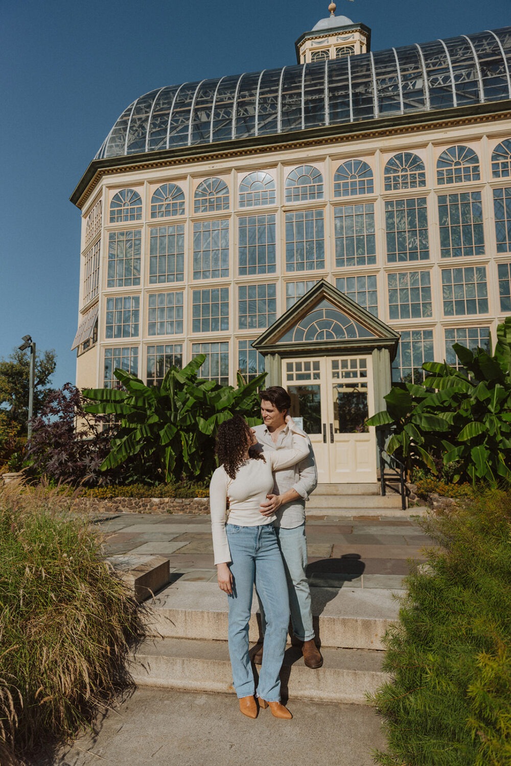 couple poses in front of the Rawlings Conservatory