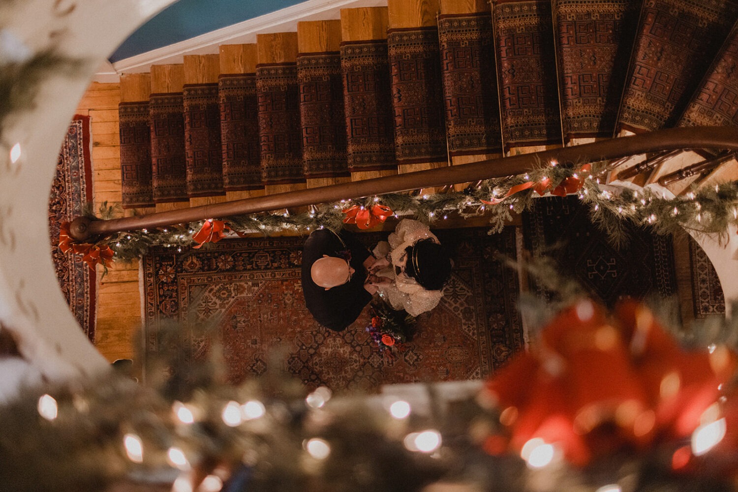 above shot of couple on the staircase surrounded with Christmas decor