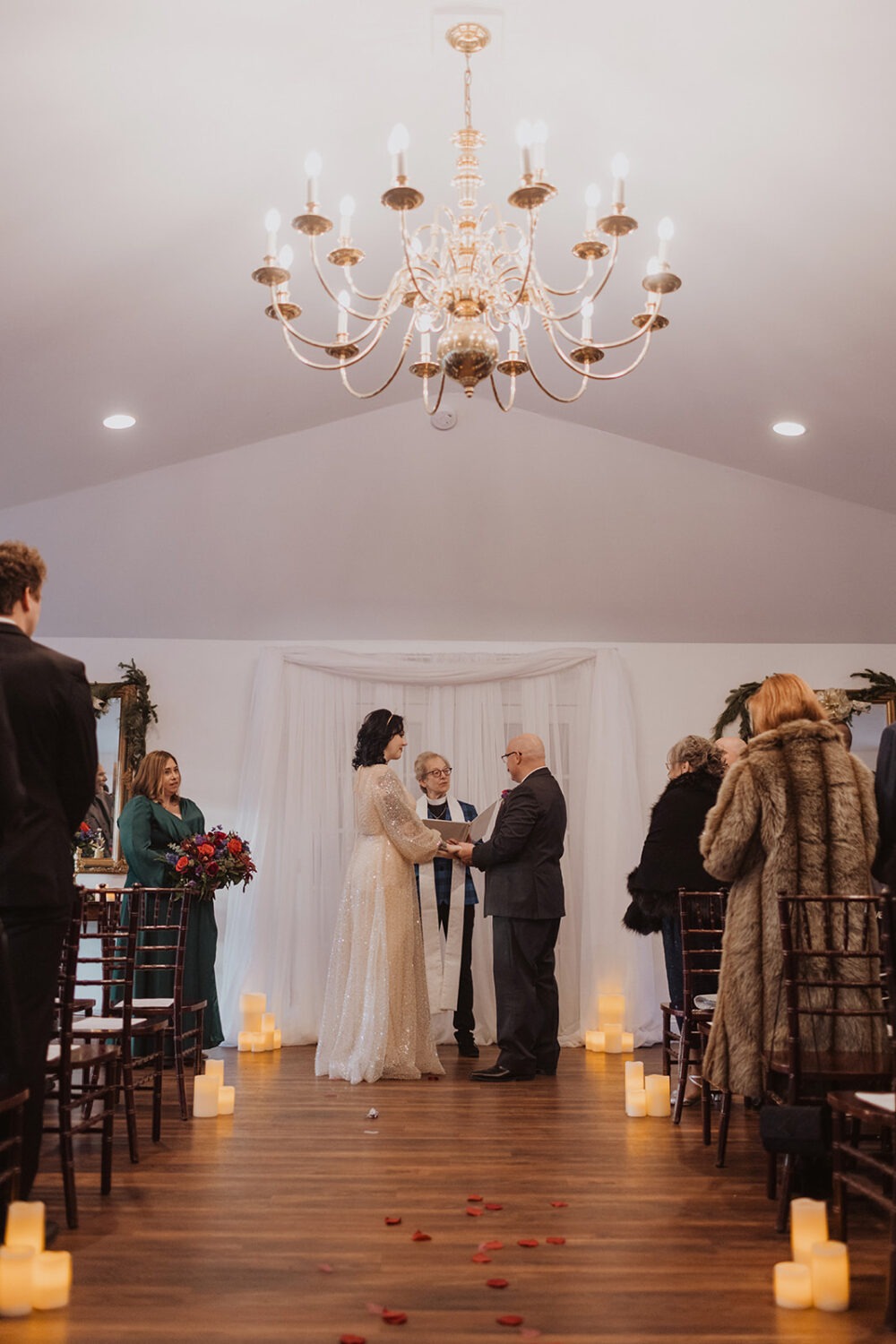 couple hold hands during Christmas wedding ceremony