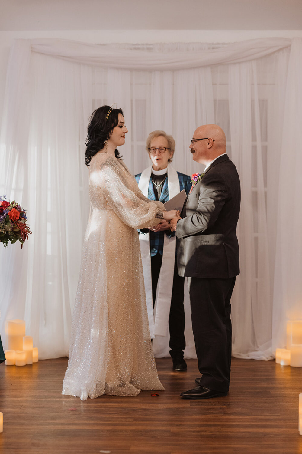 couple hold hands during Christmas wedding ceremony