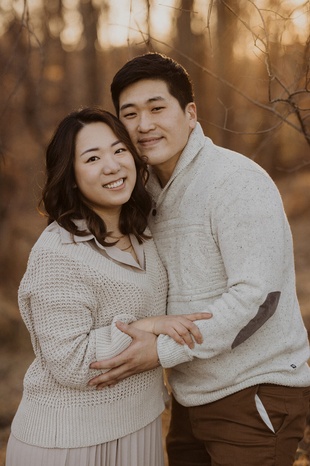 couple embrace while taking winter engagement photos at Rock Creek Park