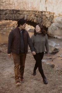 couple walking along path by a bridge in Rock Creek Park