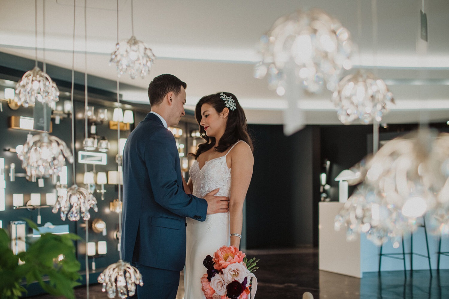 couple poses among the hanging lights in Dominion Lighting