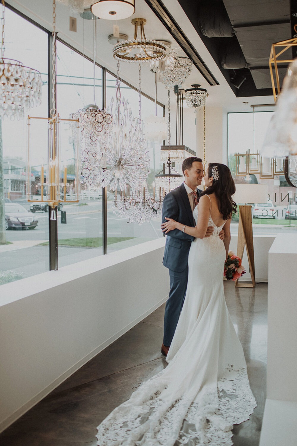 couple poses among the hanging lights in Dominion Lighting