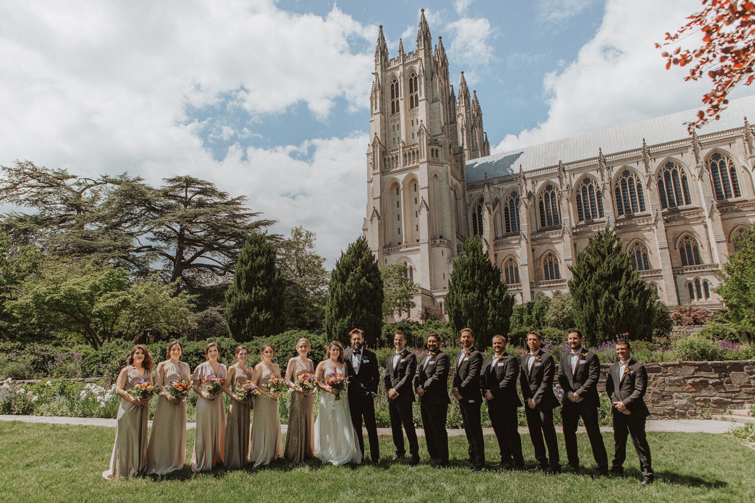 couple and wedding party pose in front of the National Cathedral