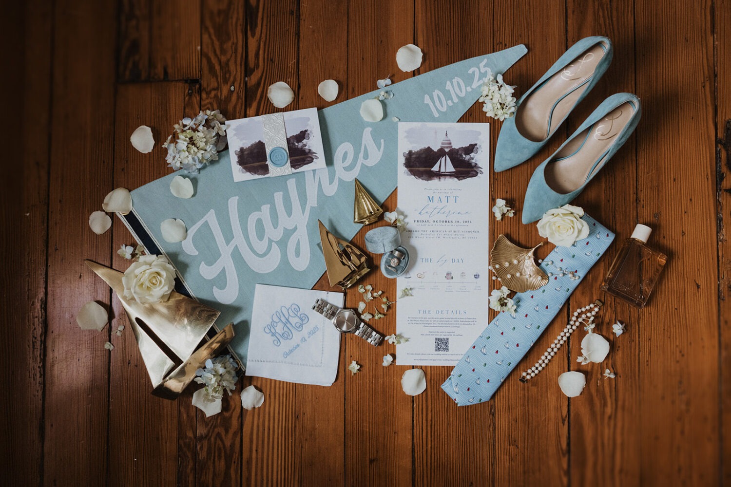 wedding flat lay including blue and white details and sailboats