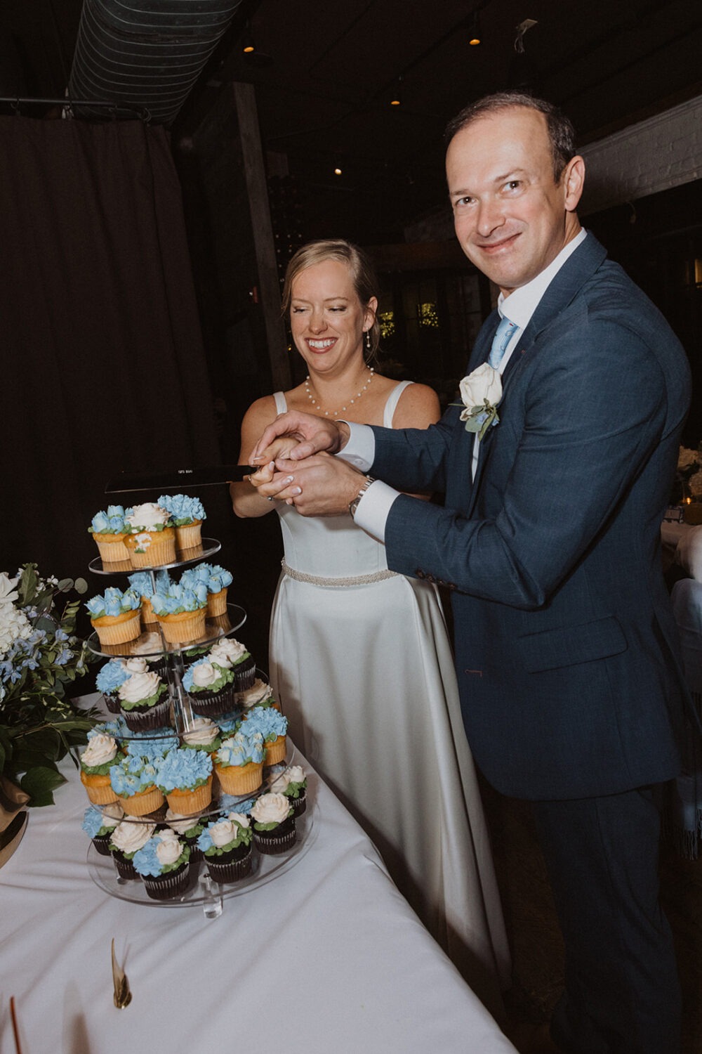 couple cut cake together