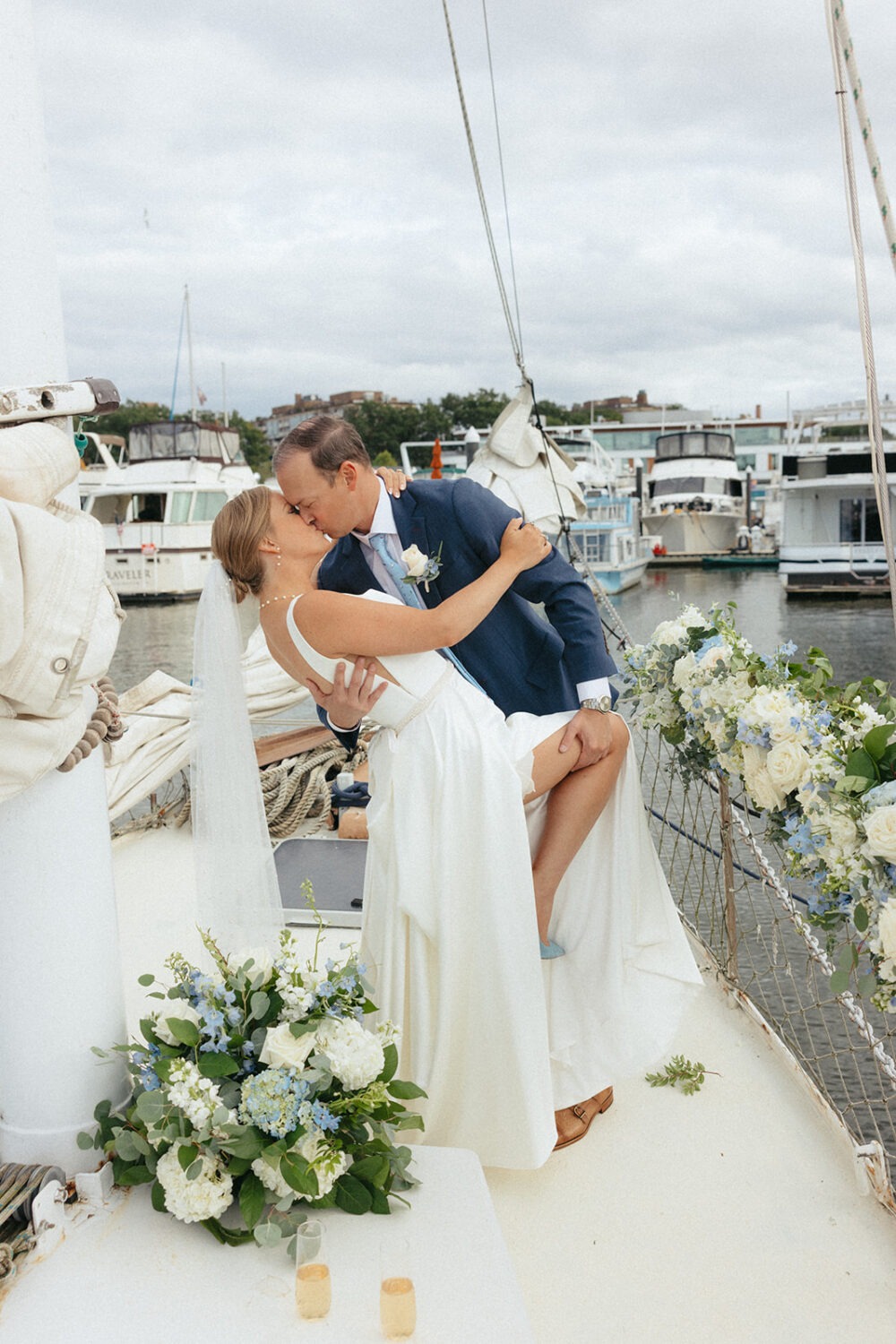 couple kiss on boat surrounded by blue and white flowers
