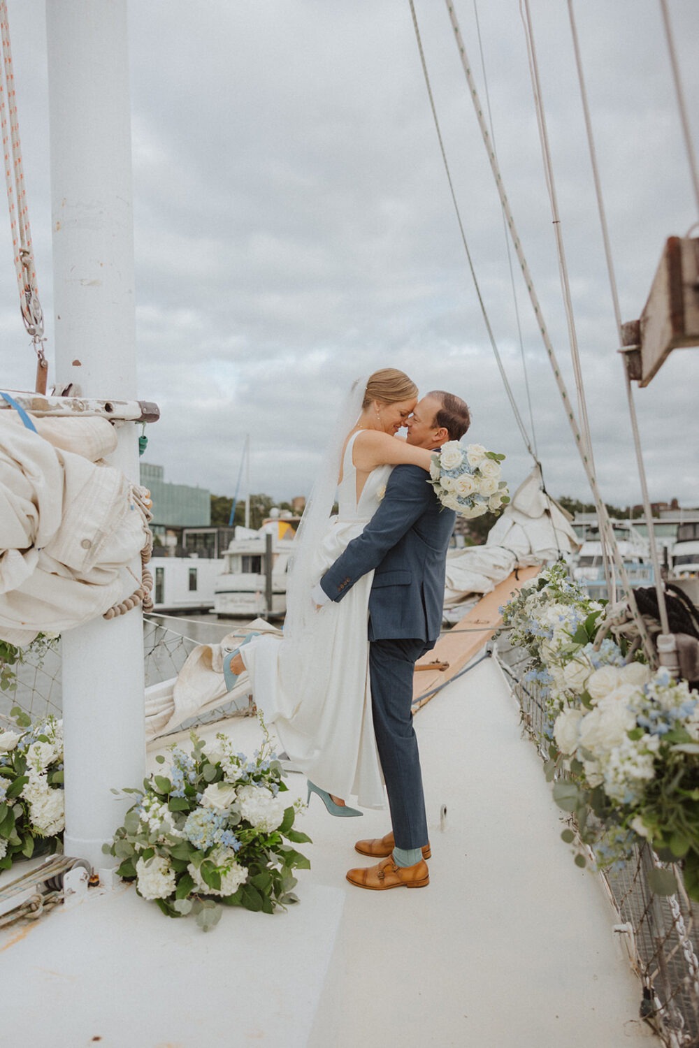 couple embrace on boat surrounded by blue and white flowers