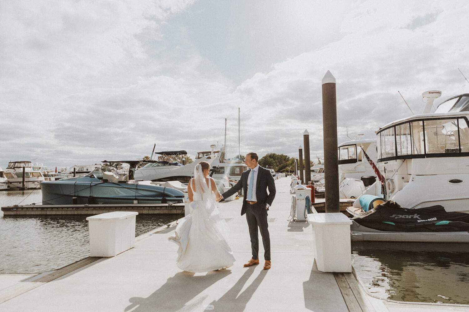 couple walk together holding hands at boating dock