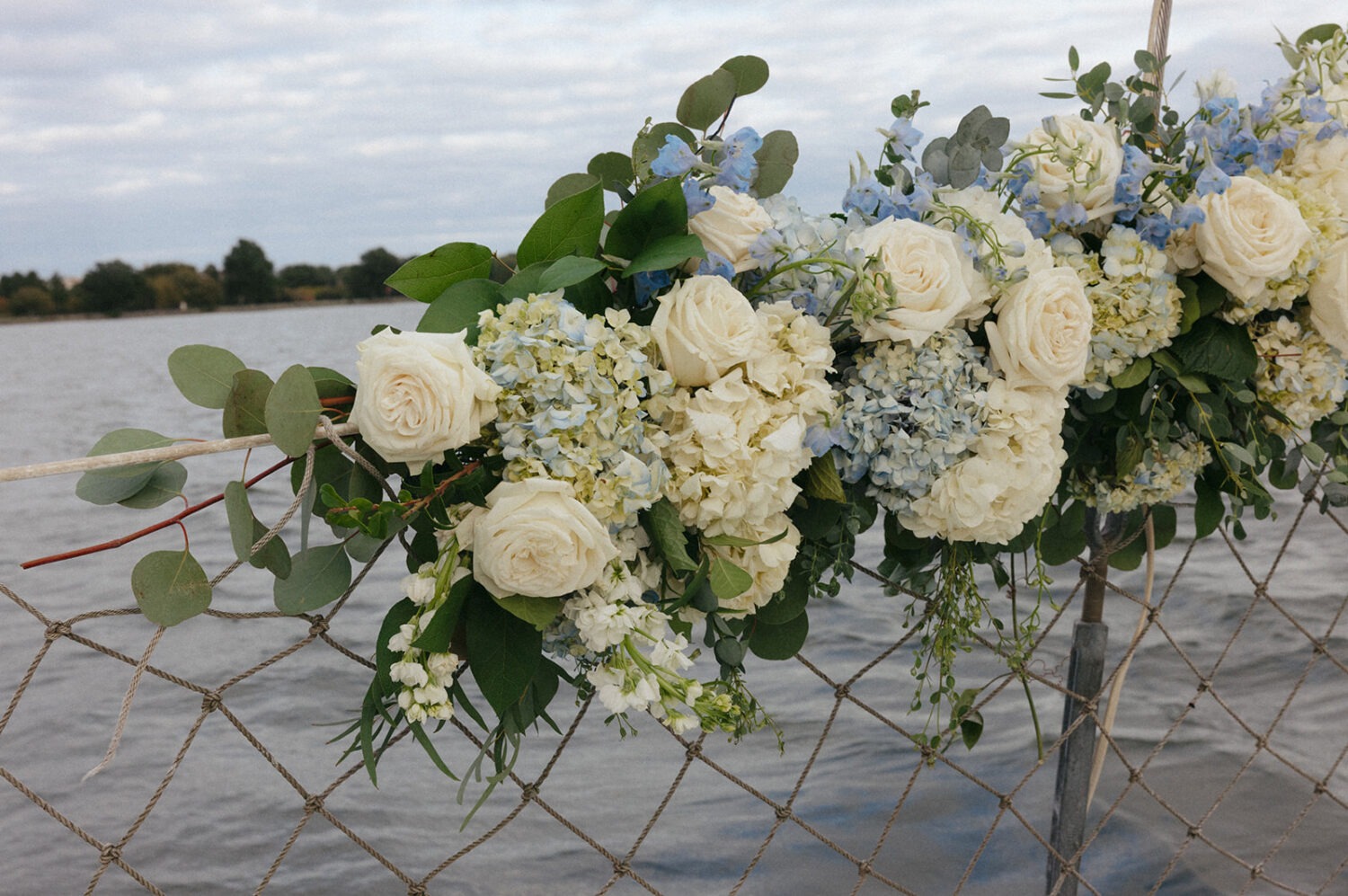 detail shot of white and blue flowers on the boat wedding