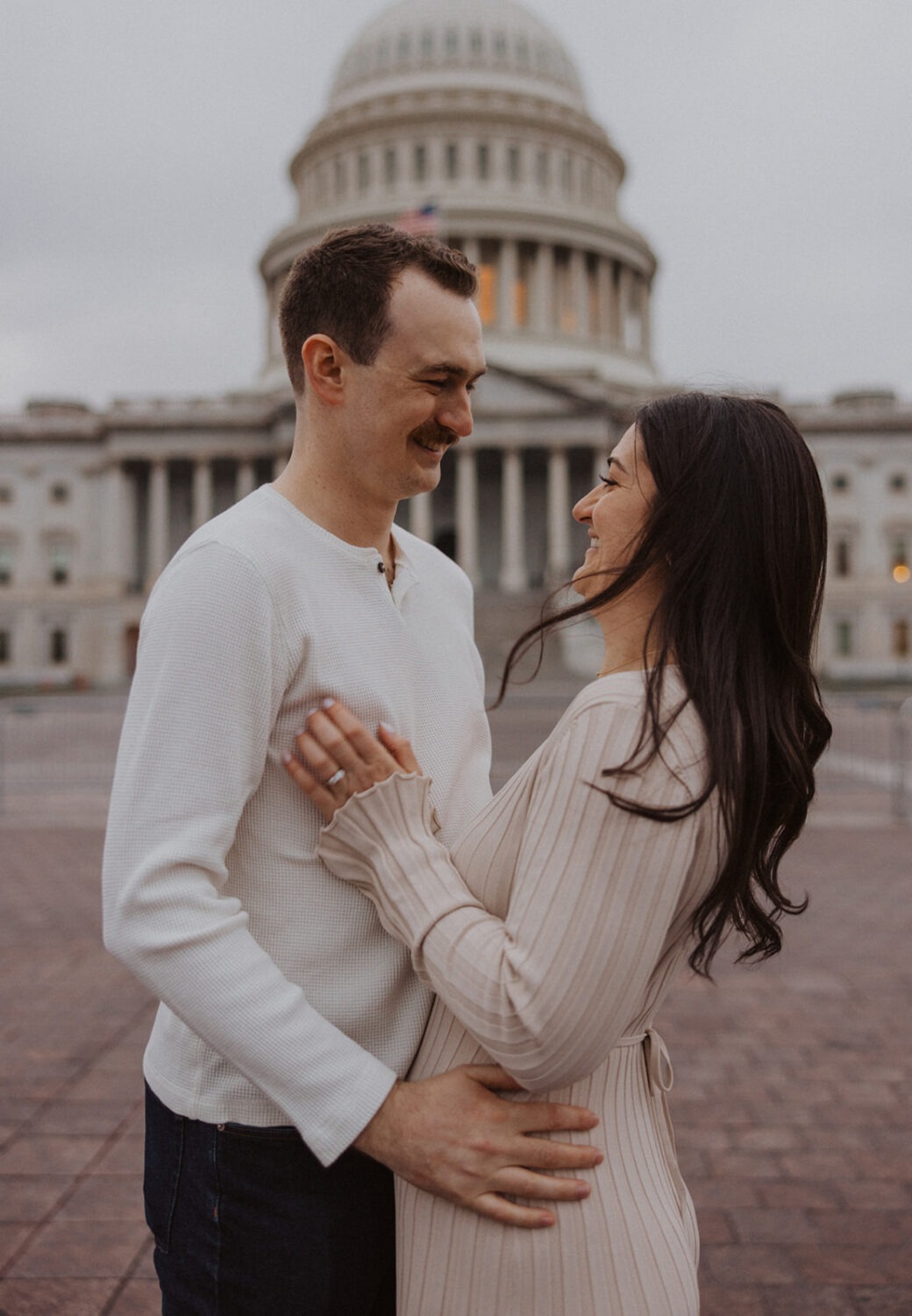 couple embrace in front of Capitol Hill DC
