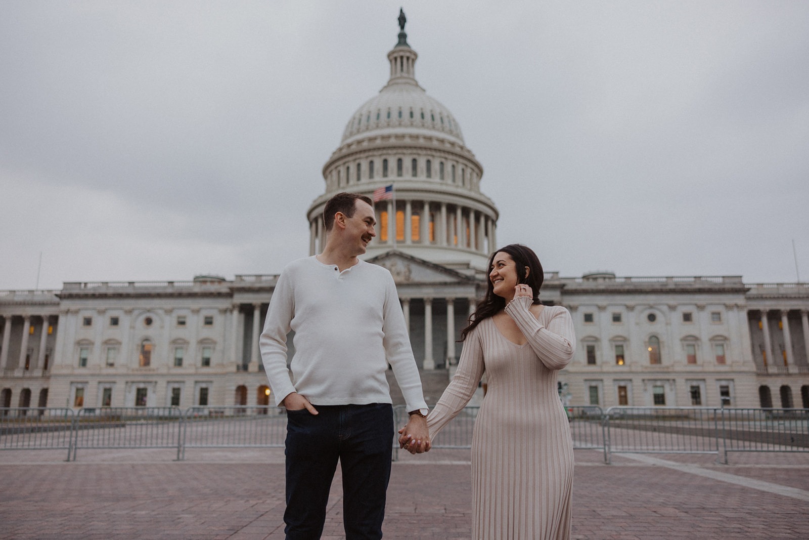 couple hold hands in front of Capitol Hill DC