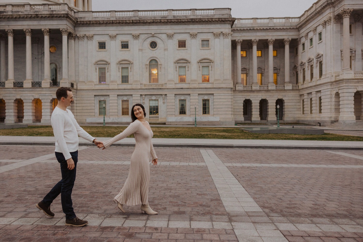 couple walk along path with Capitol Hill DC in the background