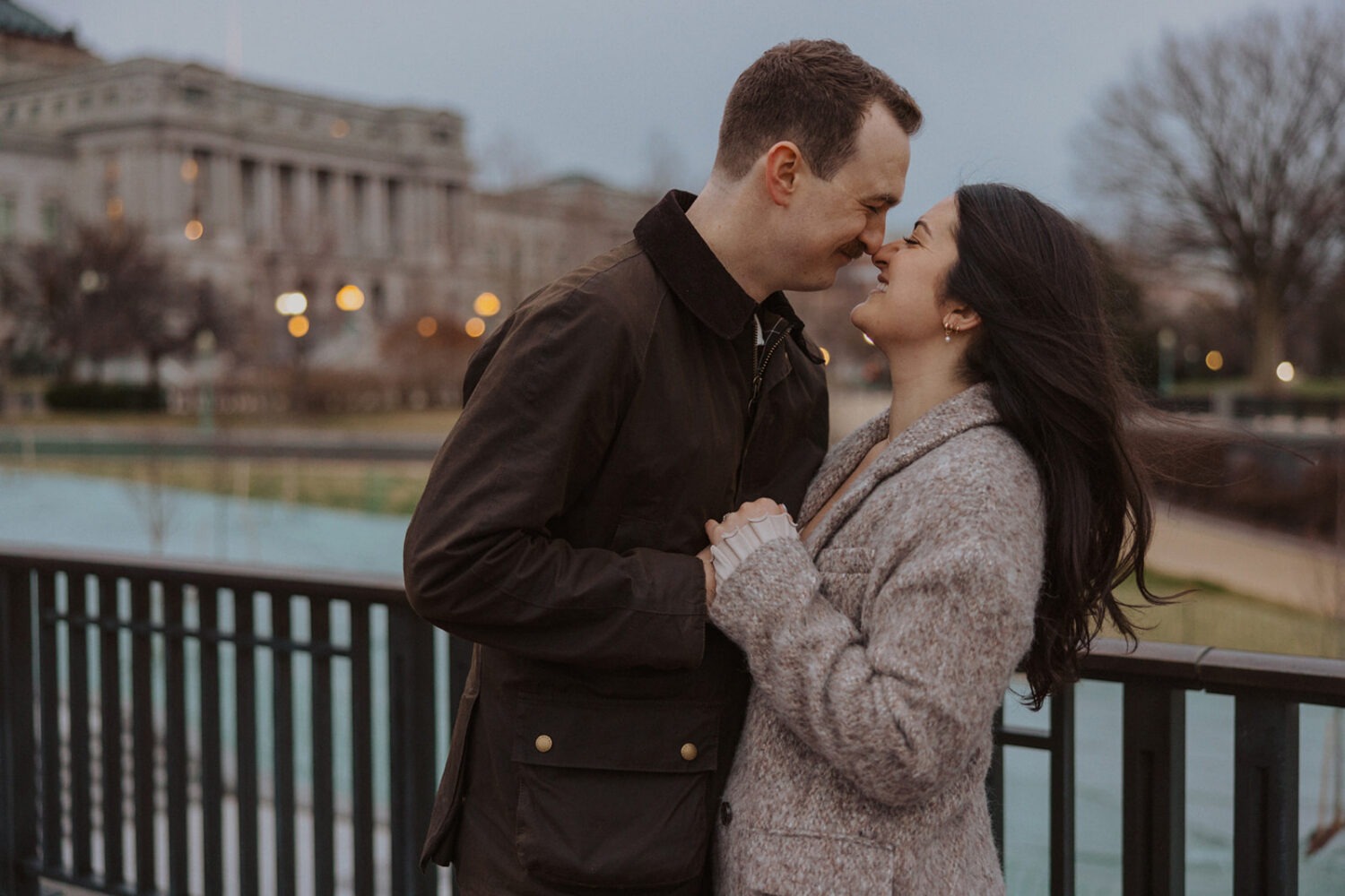 couple embrace standing in front of Lincoln Memorial