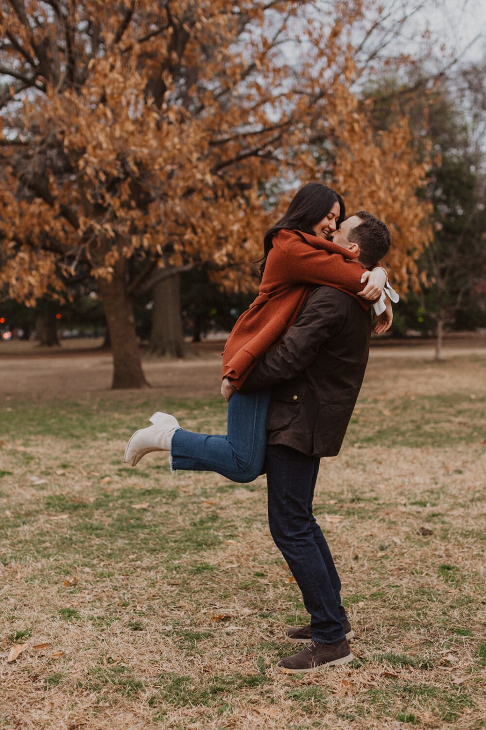 couple embrace in the middle of Lincoln Park surrounded by trees