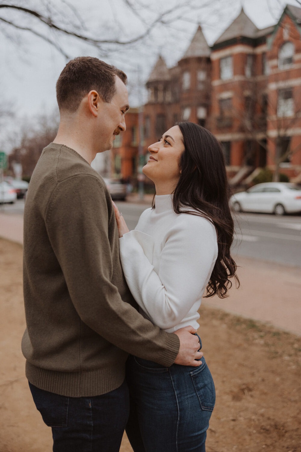 couple embrace with their Washington DC neighborhood in the background