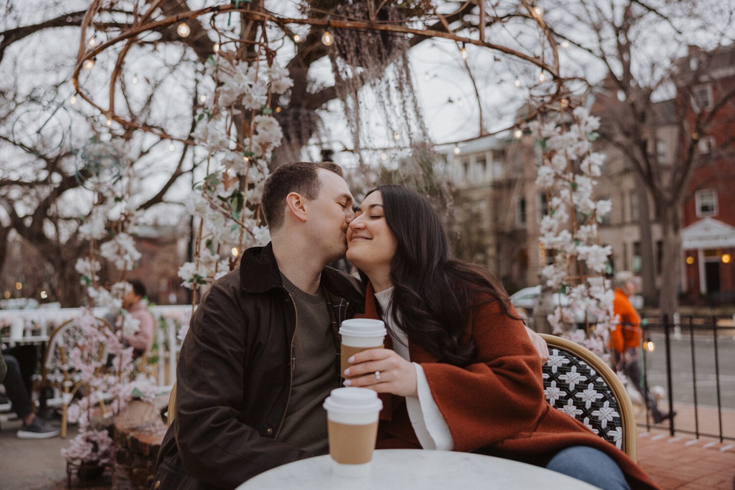 couple embrace while sitting drinking coffee 