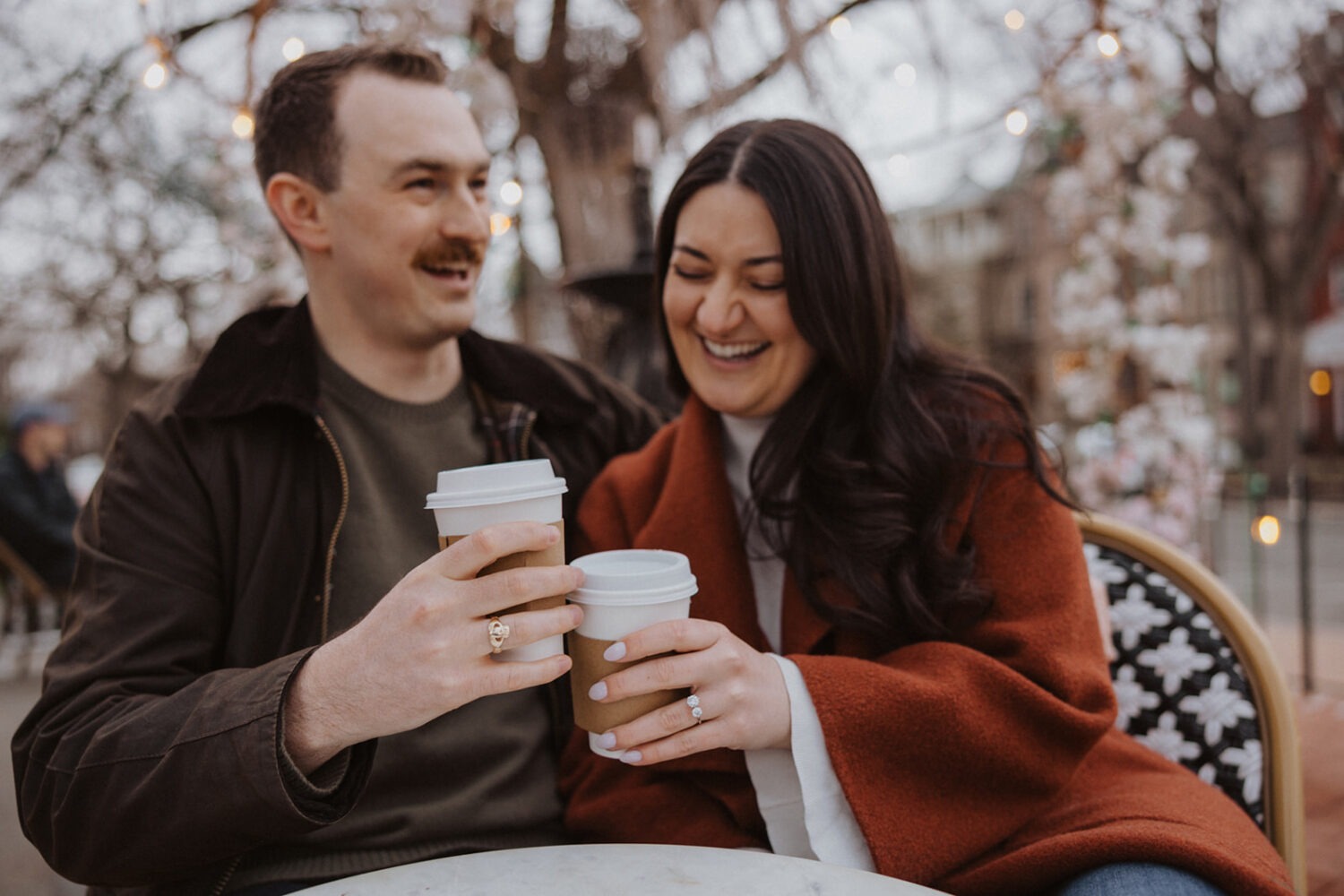 couple laughing while sitting drinking coffee 