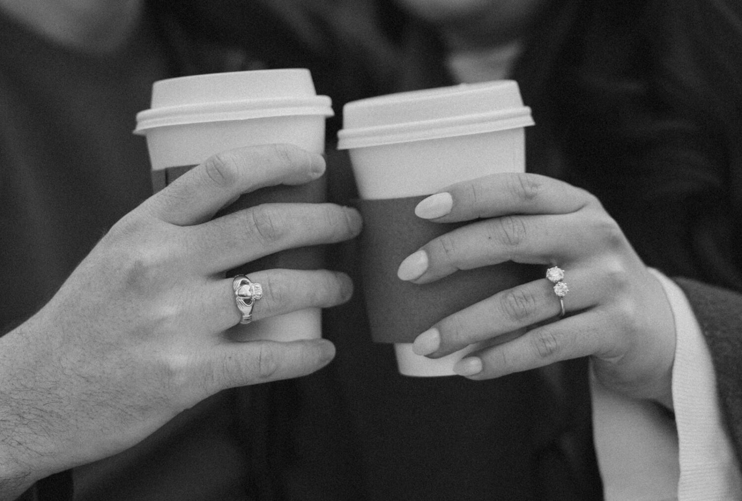 detail shot of couple's rings and coffee cups