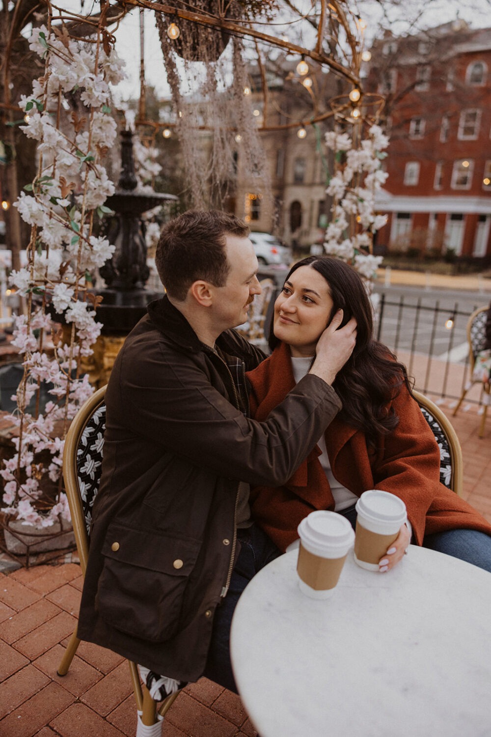 couple pose while sitting drinking coffee 