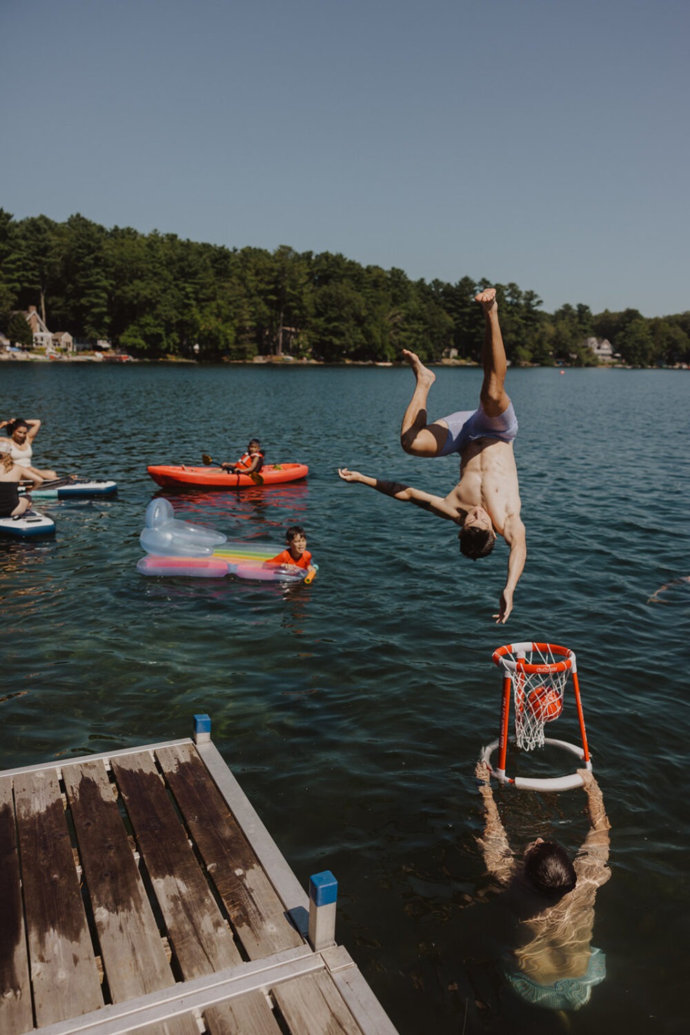family and friends playing in the lake and playing water basketball