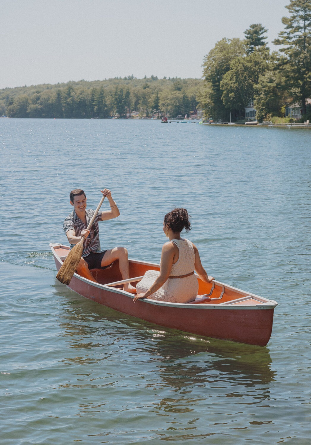 couple share a canoe on the water at the lake