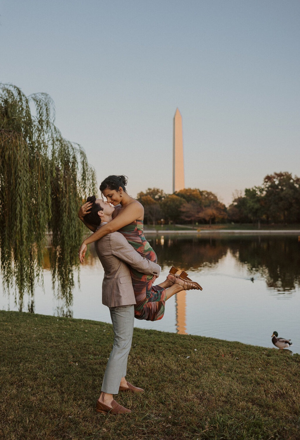 couple embrace with the Washington Monument in the background