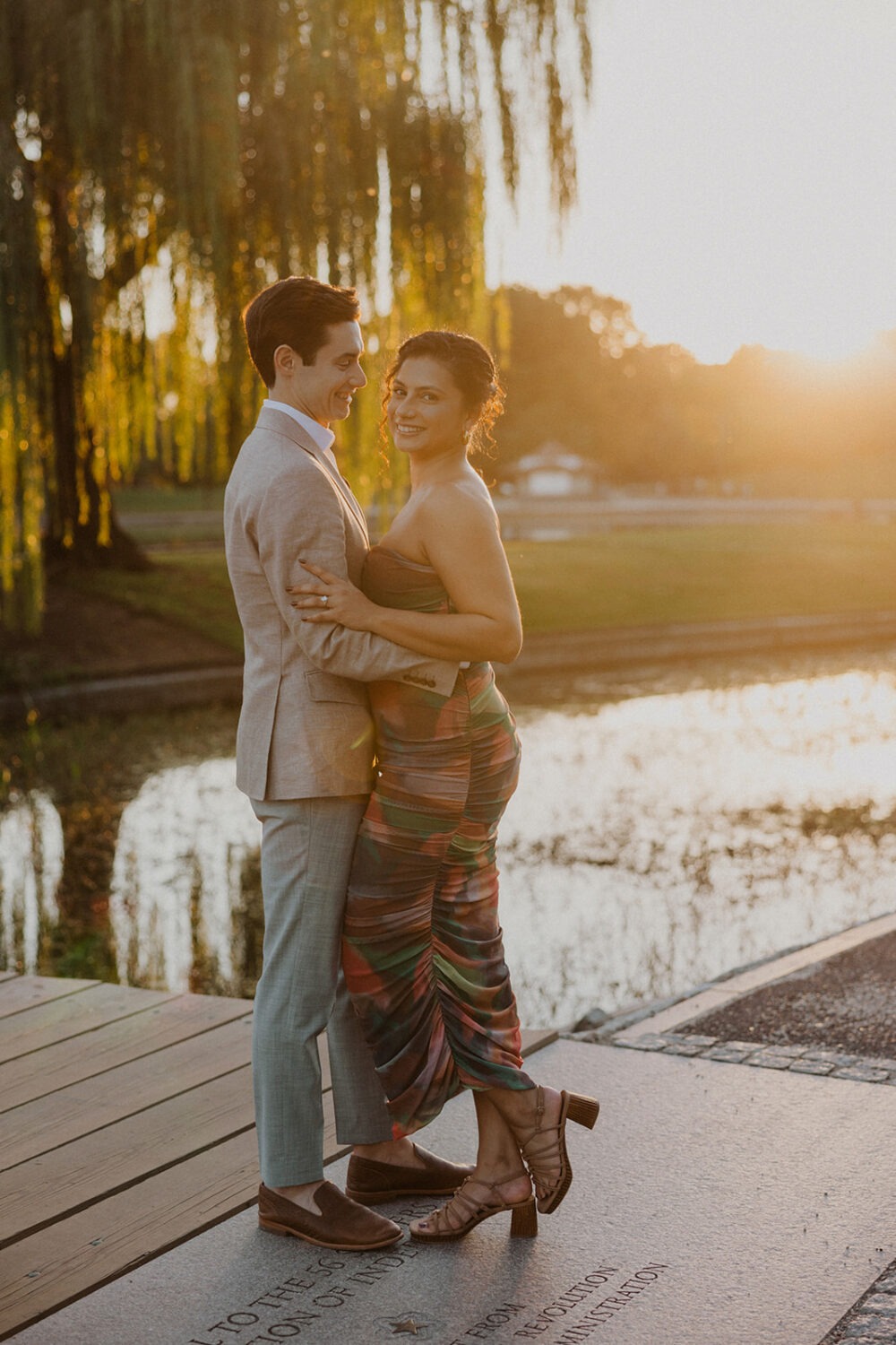 couple embrace by the water during engagement shoot
