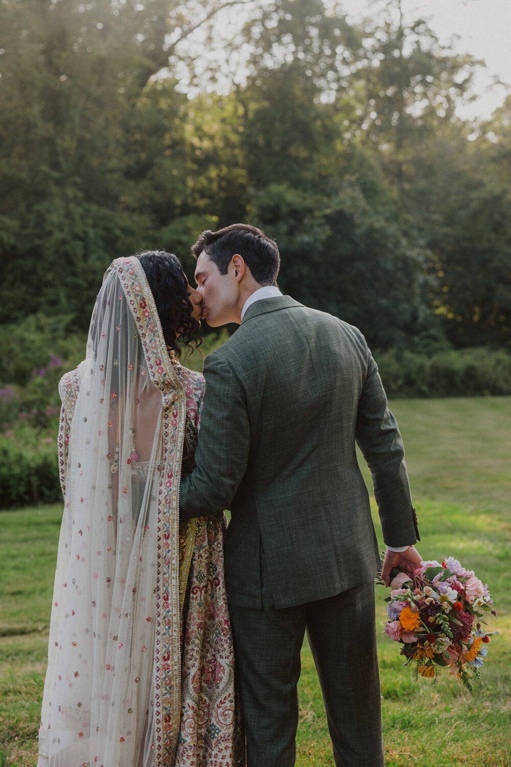 couple kiss on the lawn at sunset