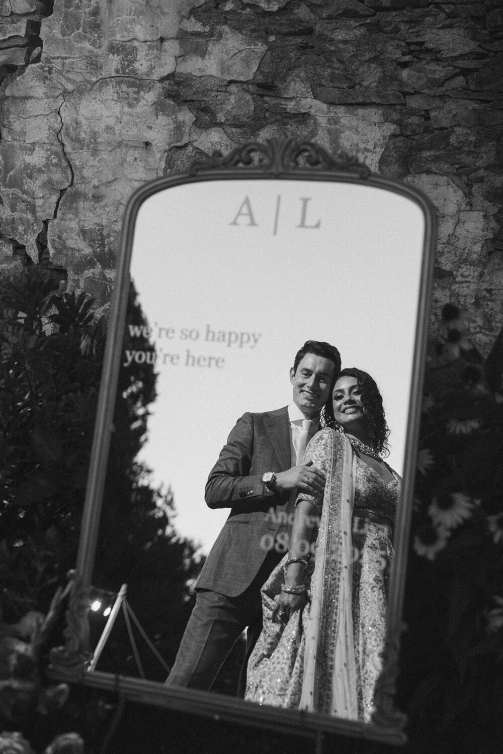 couple pose in front of mirror sign