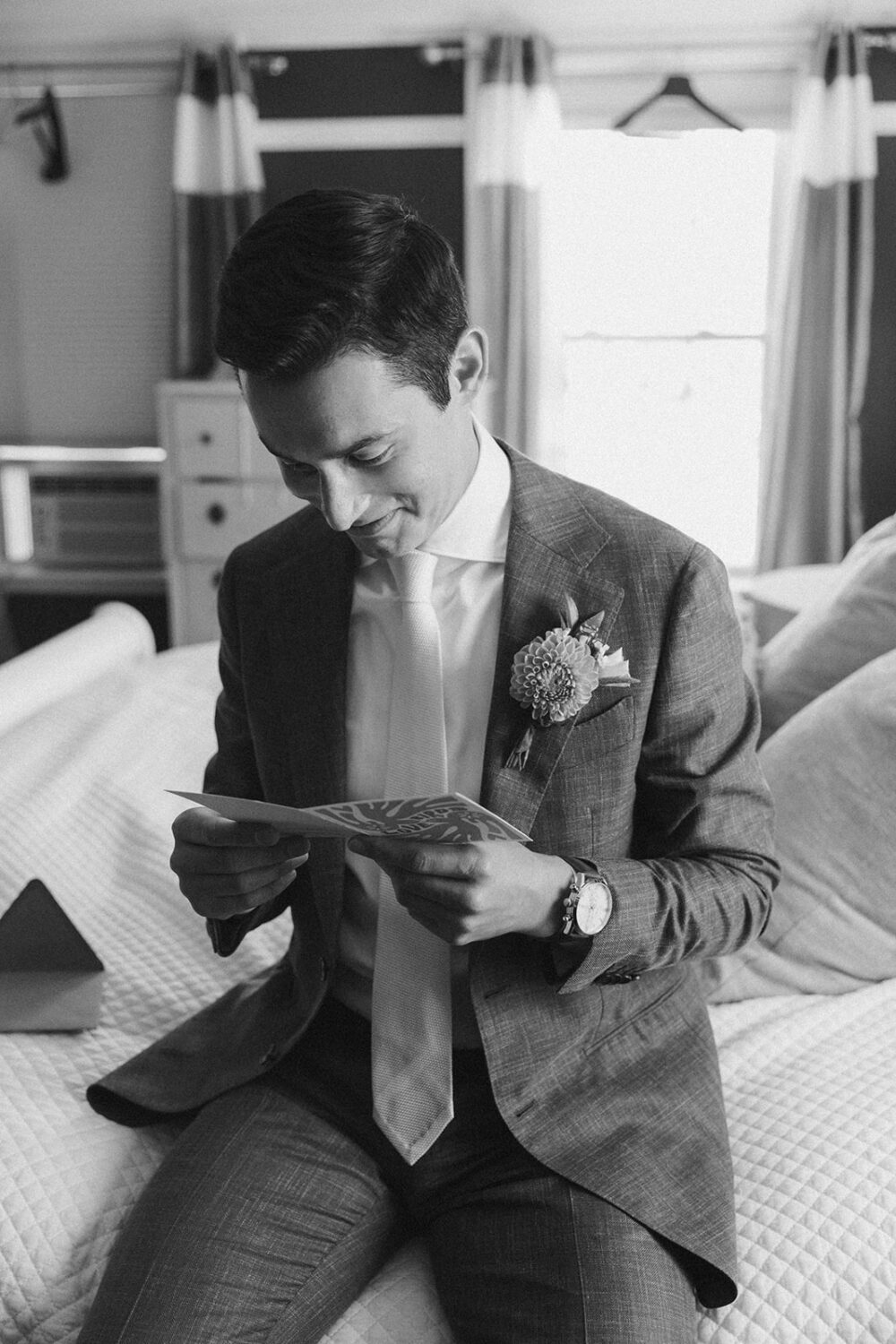 groom getting ready and reading card
