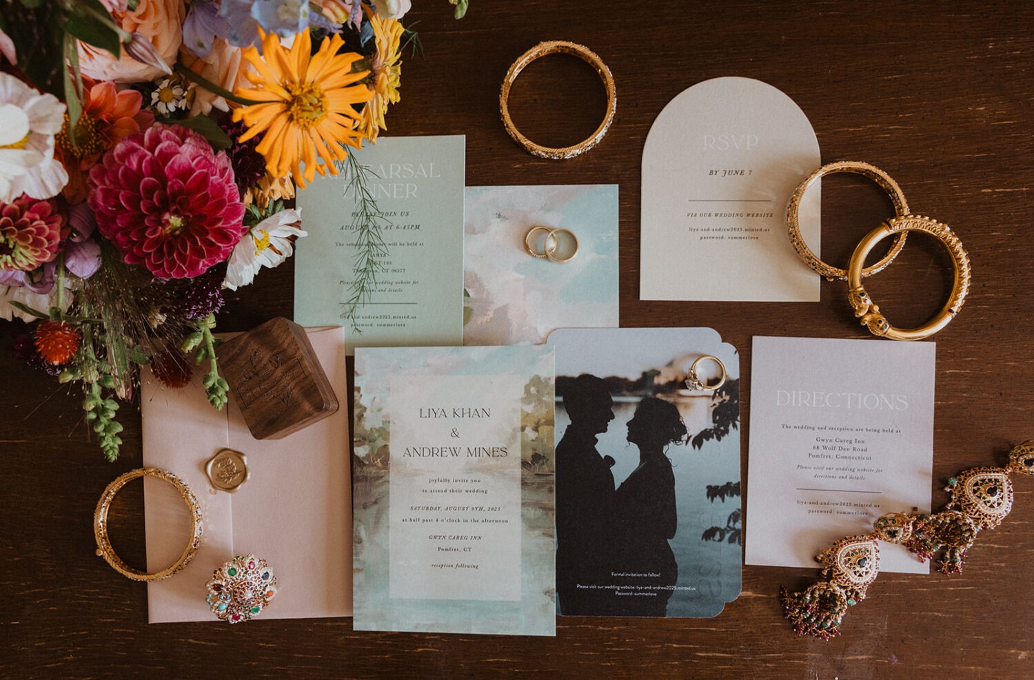 wedding flat lay including flowers, wedding invitation, and jewelry