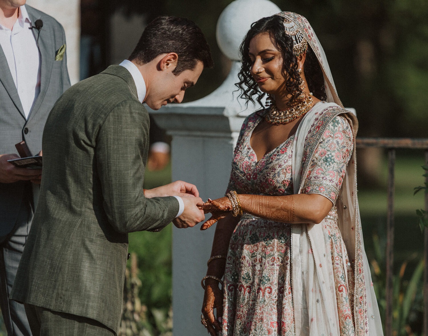 couple exchange rings during mansion wedding ceremony