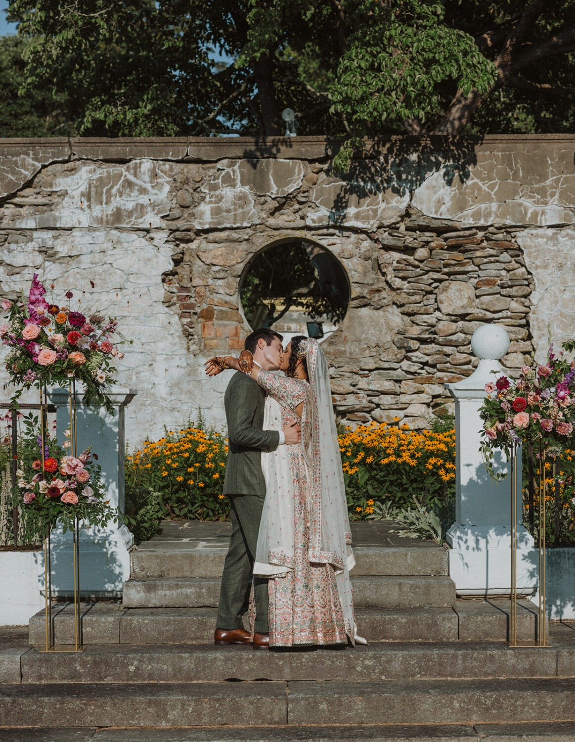 couple kiss during mansion wedding ceremony