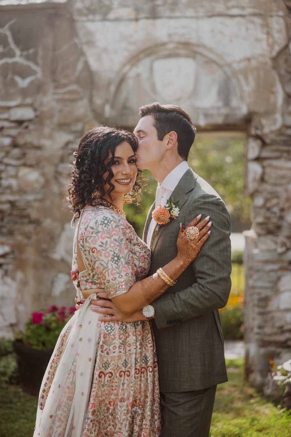 couple pose together in front of stone wall