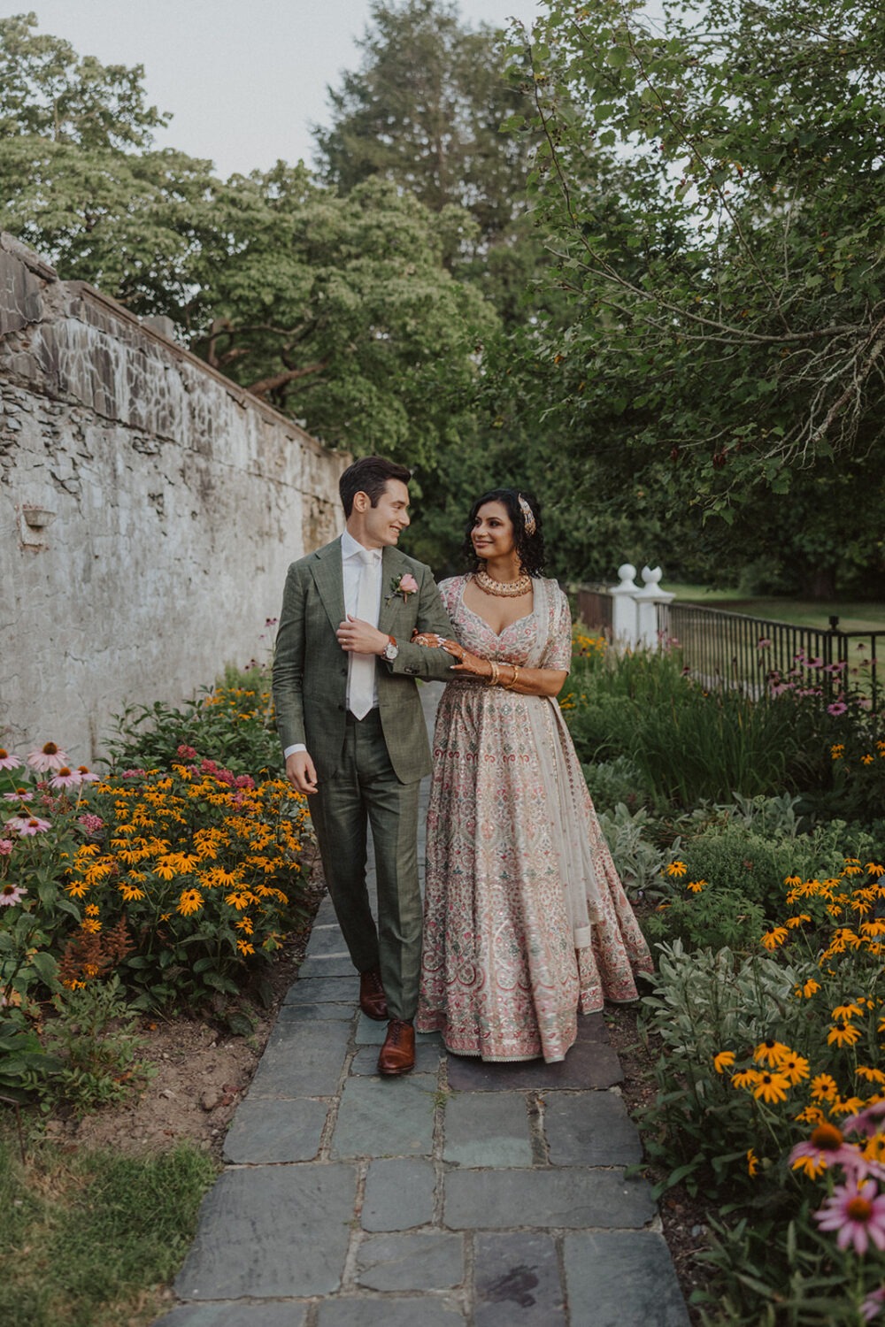 couple walk together through flower garden