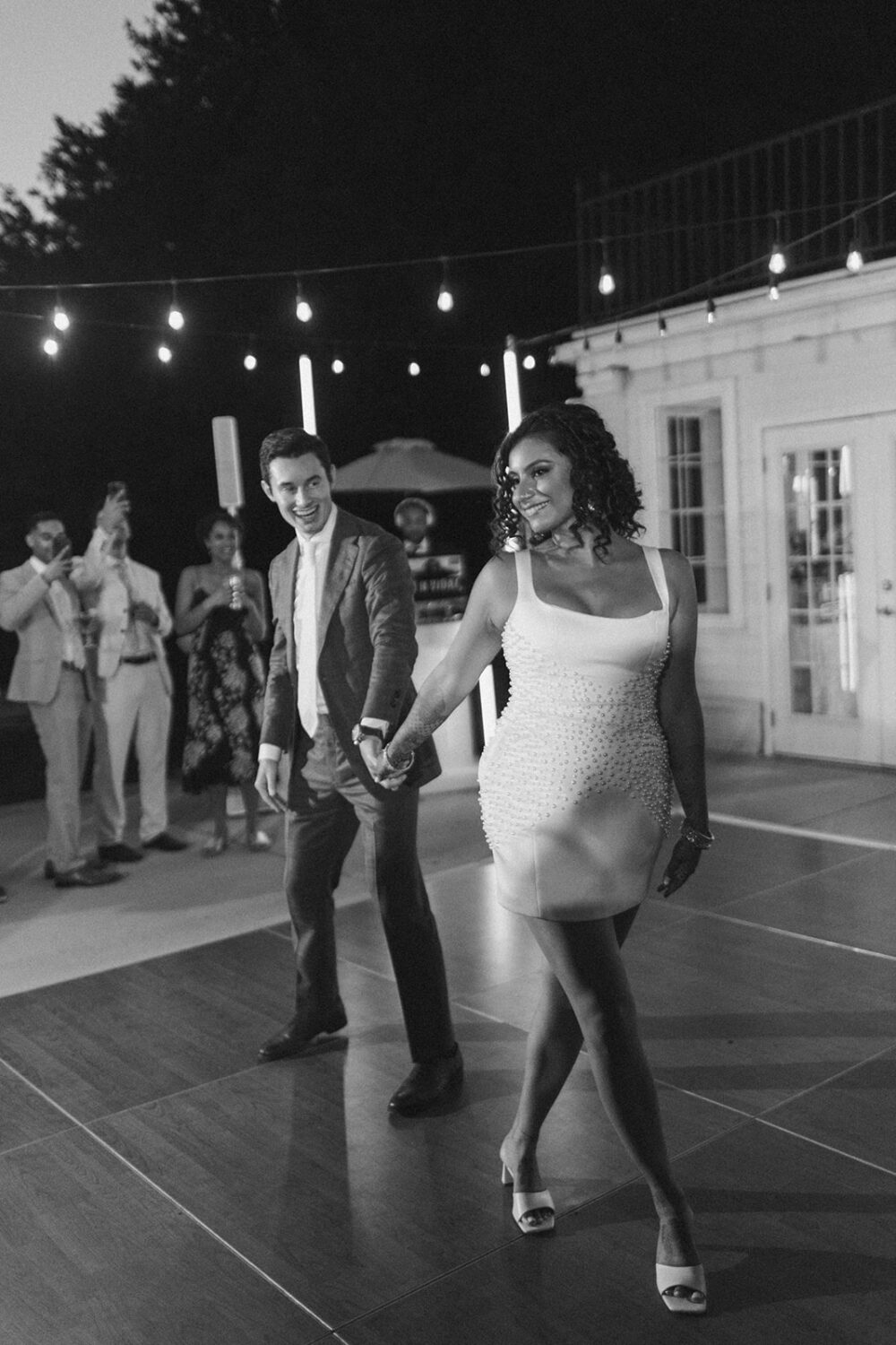 couple dance together during reception under twinkle lights