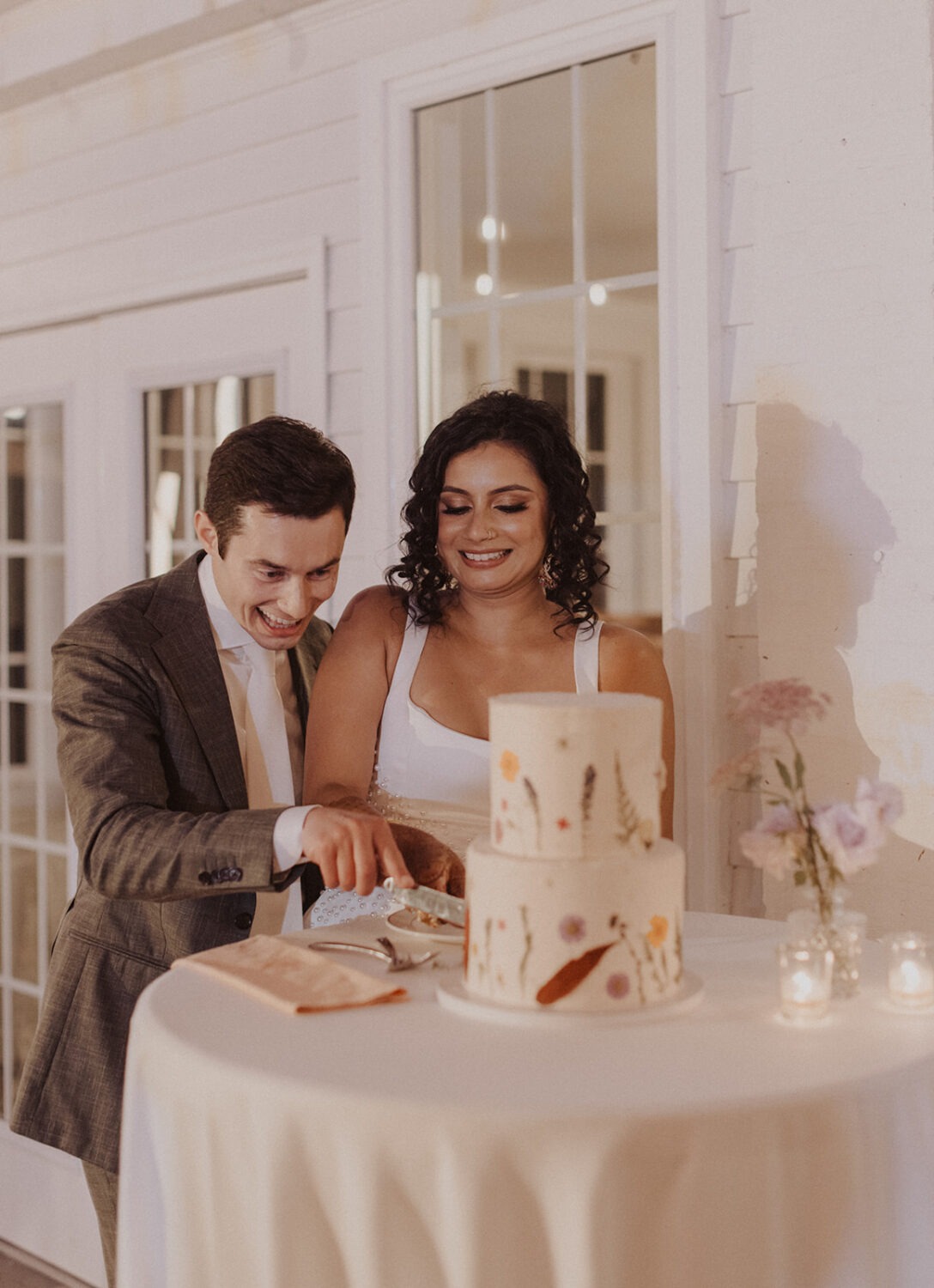 couple cut wedding cake together