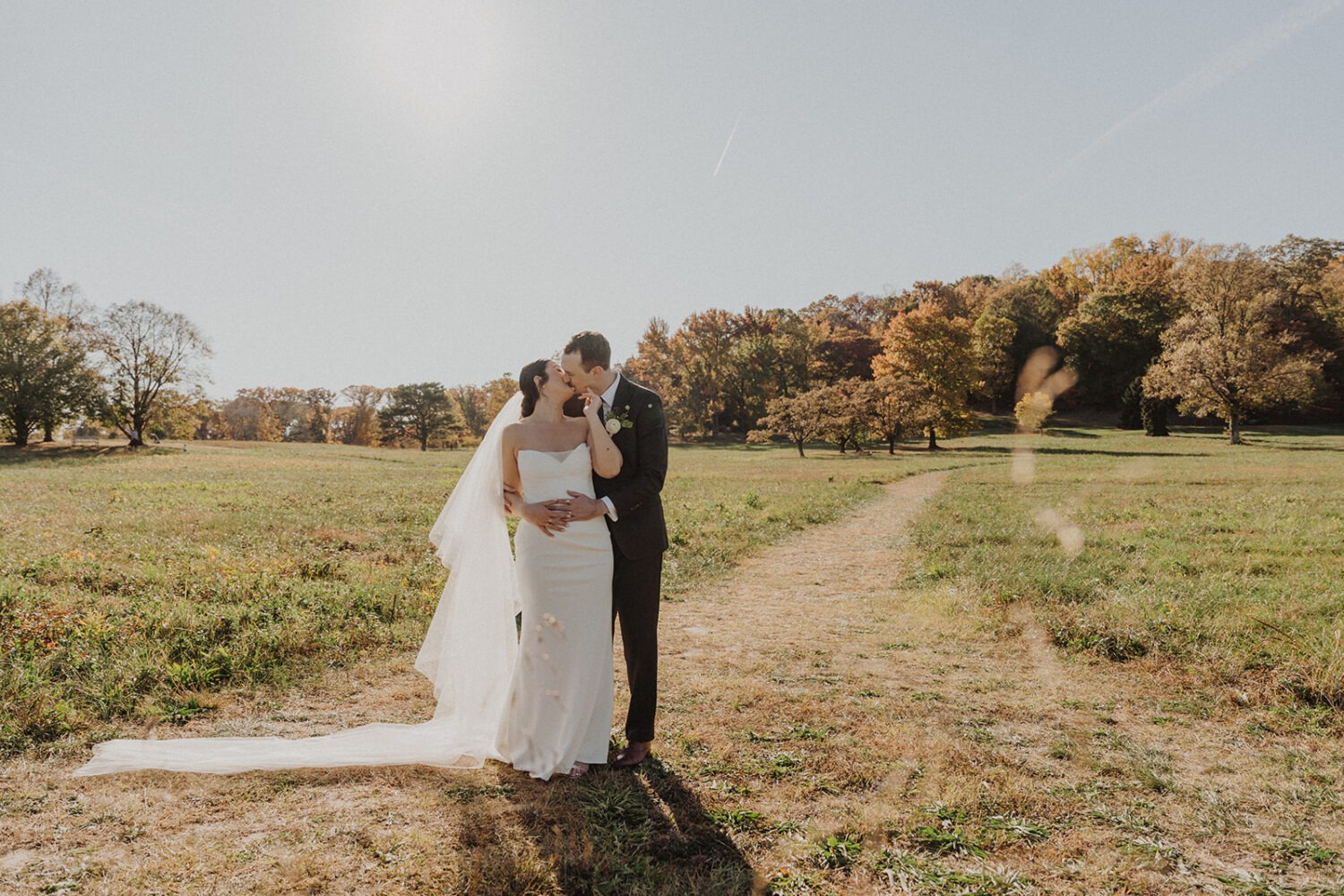 couple kiss with the meadows in the background of their National Arboretum wedding