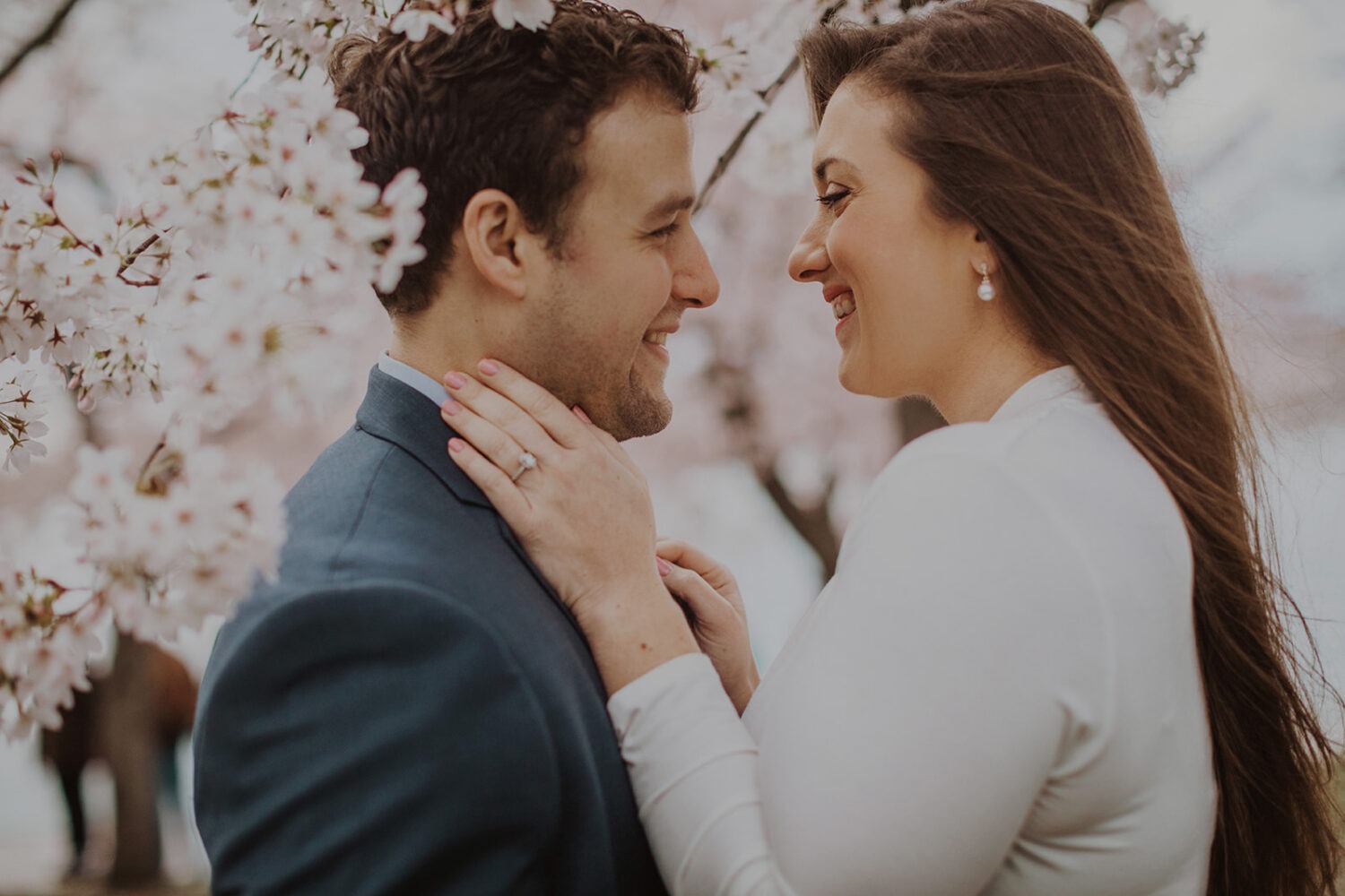 couple embrace in the cherry blossom trees