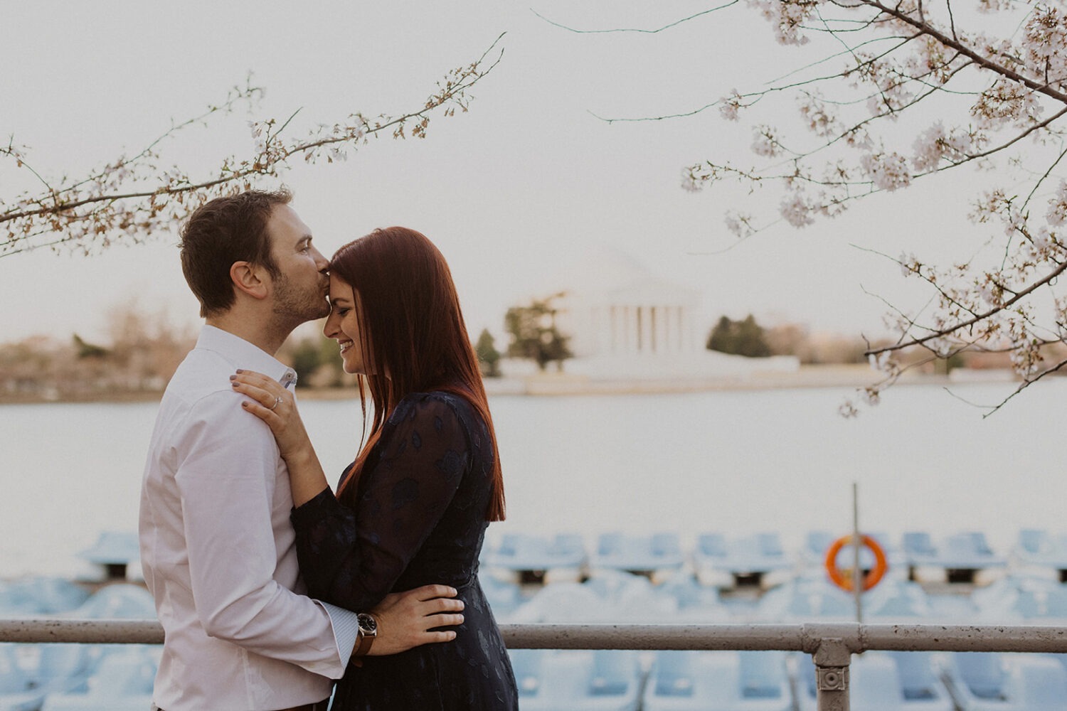 couple embrace along the water overlooking the Lincoln Memorial