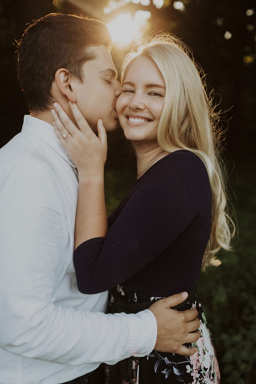 couple kiss during sunset engagement photos