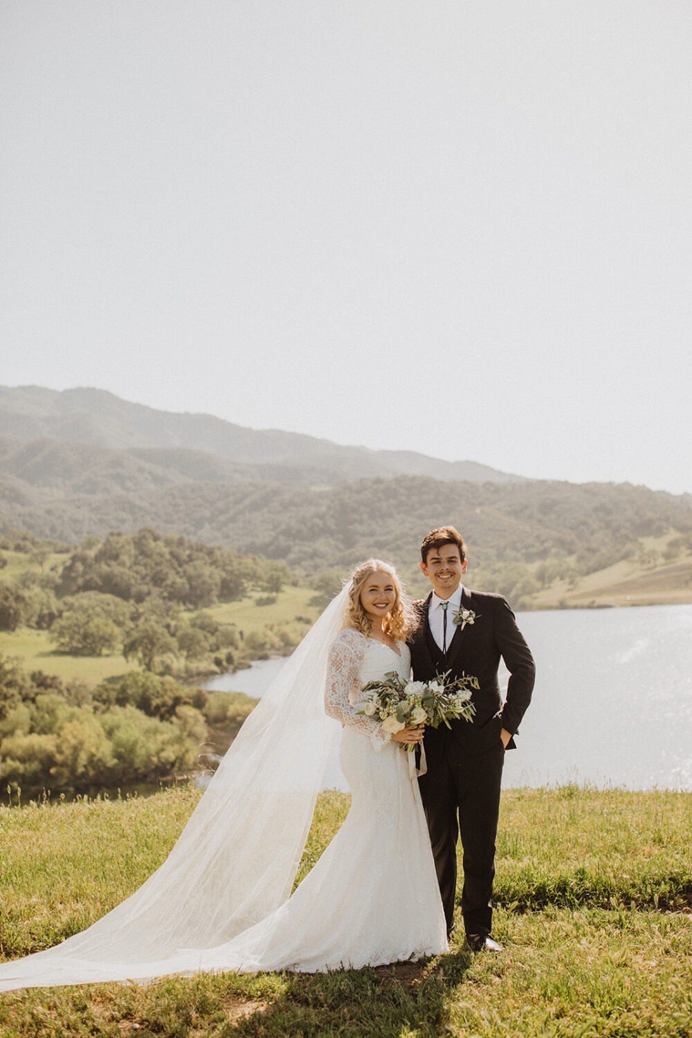 couple pose in front of lake at Alisal Ranch spring wedding