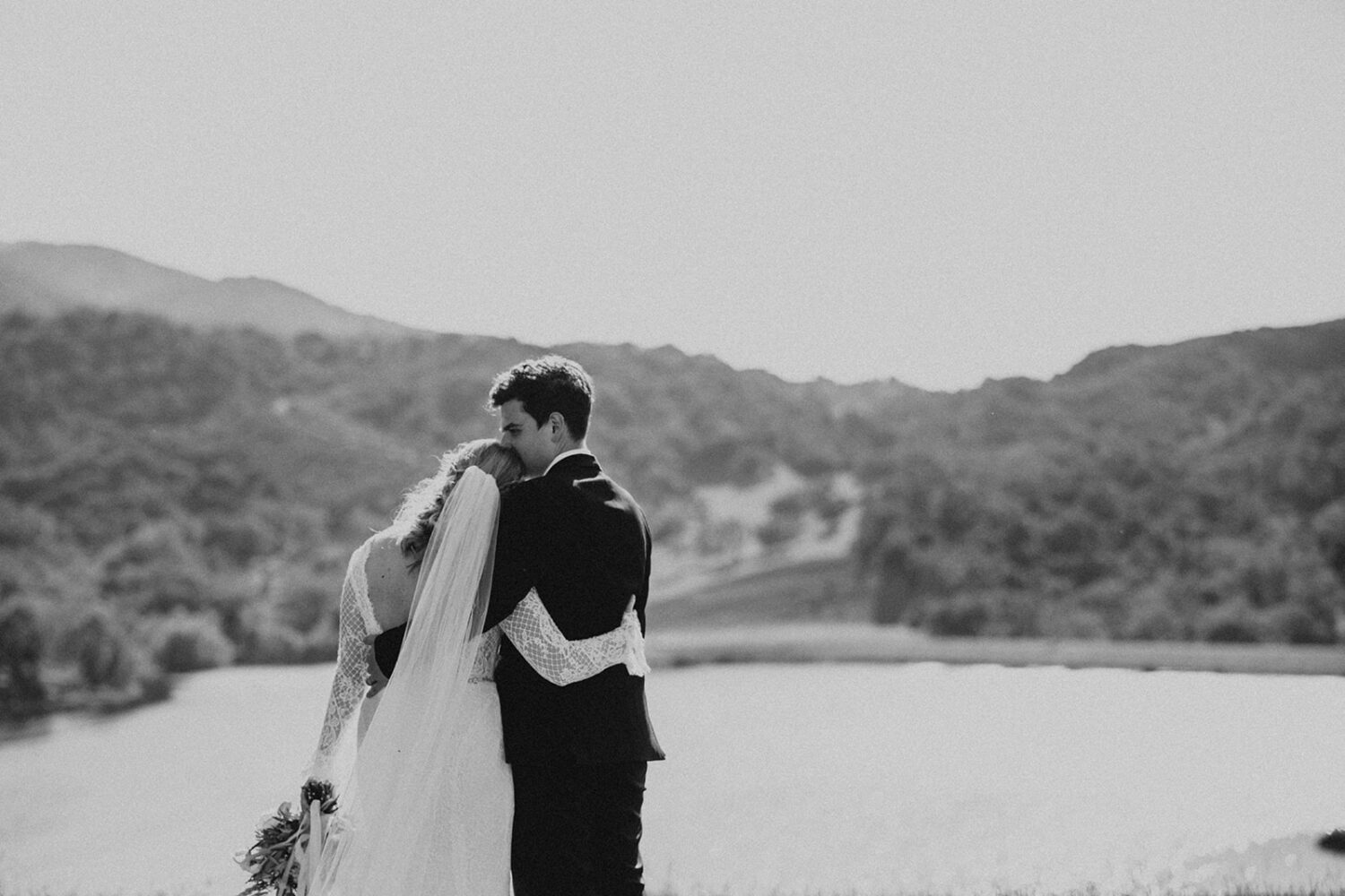 couple embrace in front of lake