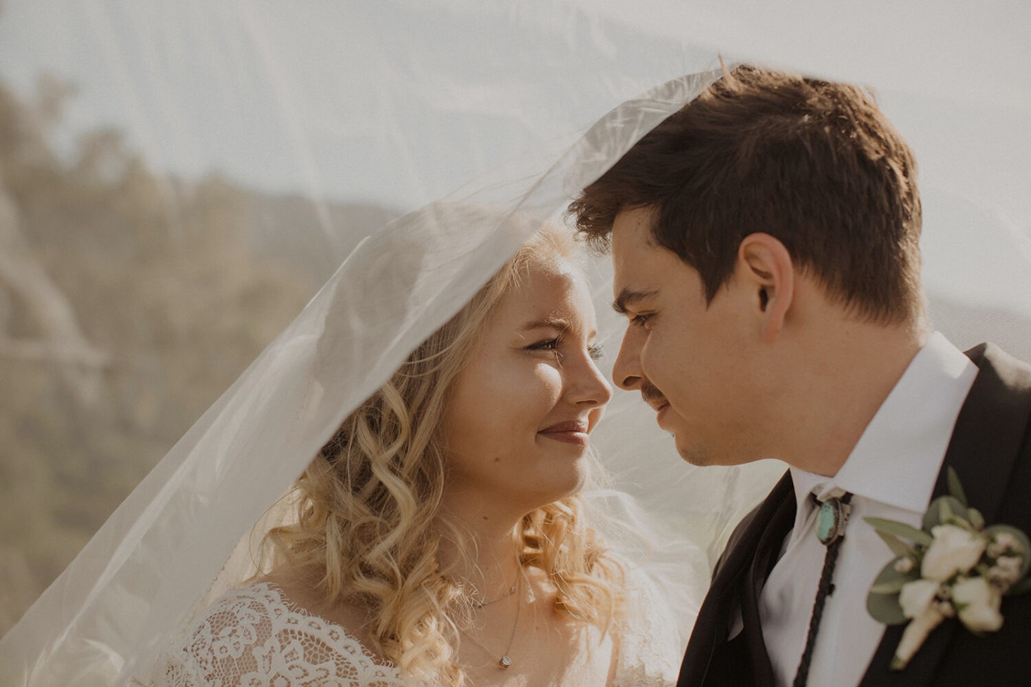 close up of couple looking at each other under veil