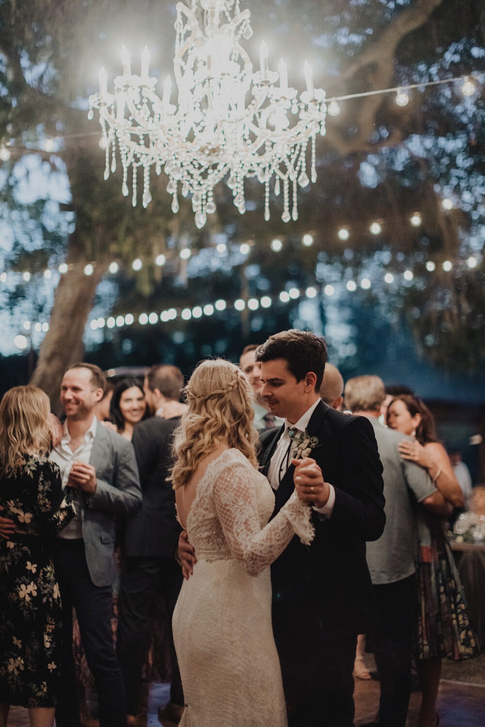 couple dancing during reception surrounded by friends and family