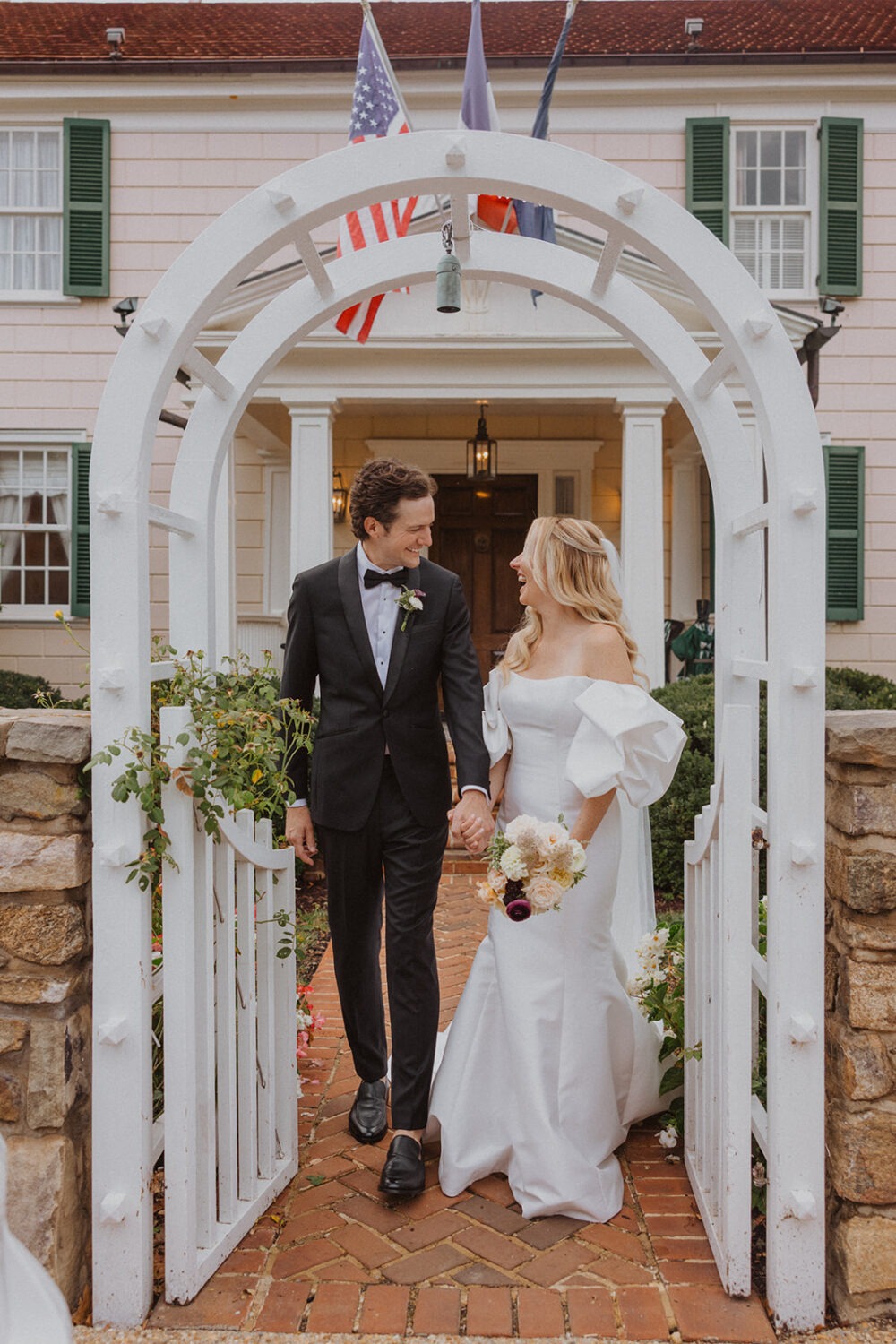 couple laughing together under arbor at the inn
